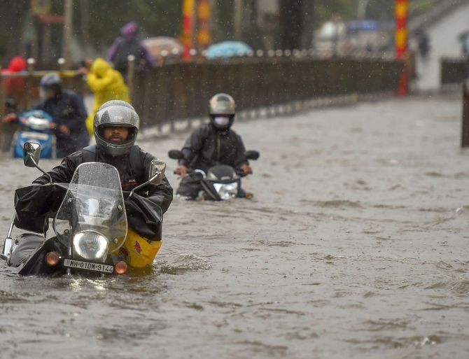 Commuters wade through a waterlogged street following heavy monsoon rain at Sion in Mumbai. Photograph: Kunal Patil/PTI Photo